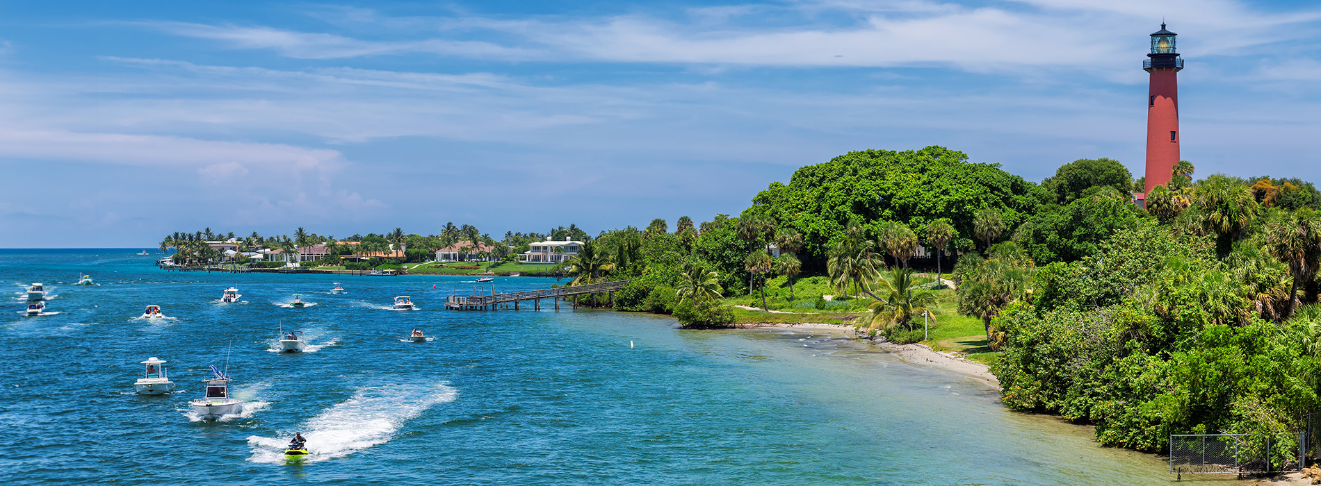 The image features a picturesque coastal scene with a lighthouse, boats on the water, and palm trees, suggesting a tropical location.